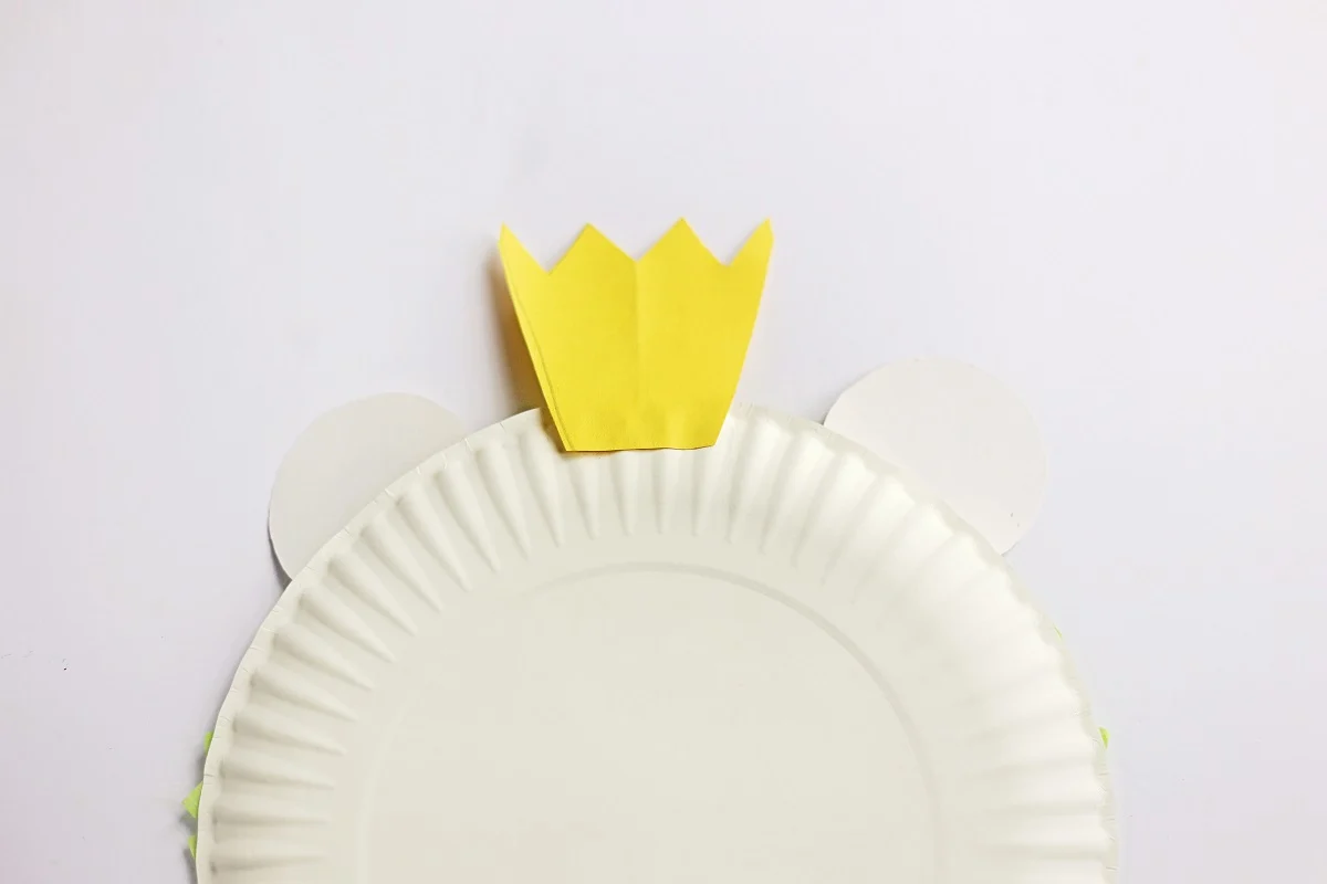 Back of paper plate showing where to glue yellow crown.