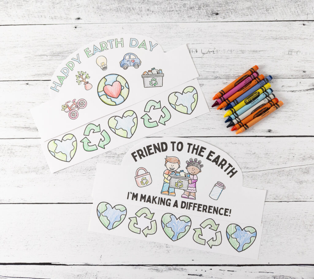 Two different paper headband designs with an environmental theme on them colored with crayons and colored pencils.