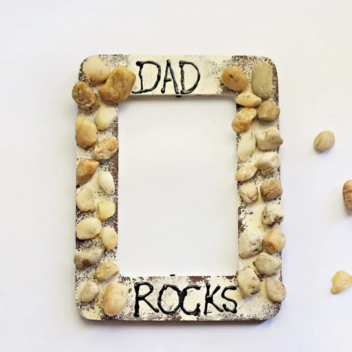 Finished My Dad Rocks craft. The picture frame is painted and glued on rocks resemble rocks cemented in a wall.