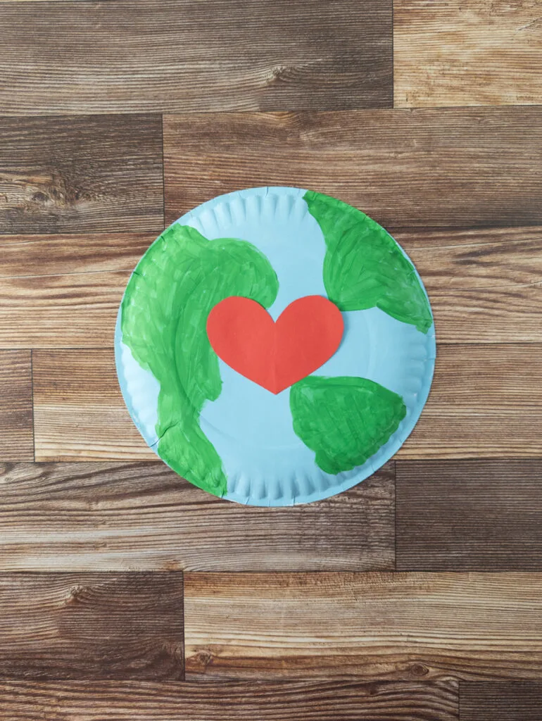 Earth craft made by painting paper plate blue and green. Red heart added to the center.