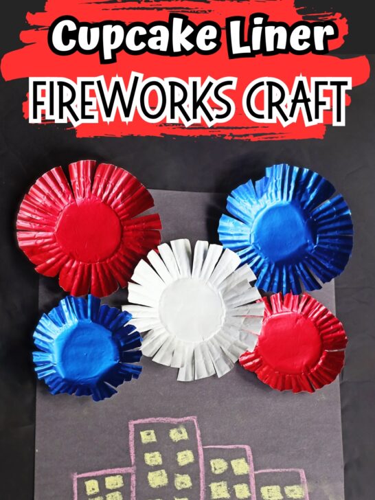 White and black text says Cupcake Liner Fireworks Craft with a red brush stroke behind it. Below is a photo of a craft project with buildings drawn on black paper and assorted red, white, and blue baking cups glued to it.