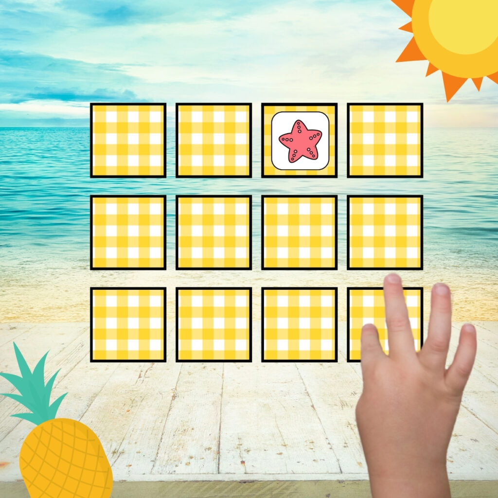 Twelve cards are in a grid pattern, with one flipped face up to show a starfish. A child's hand touches another card to see if it is a match.