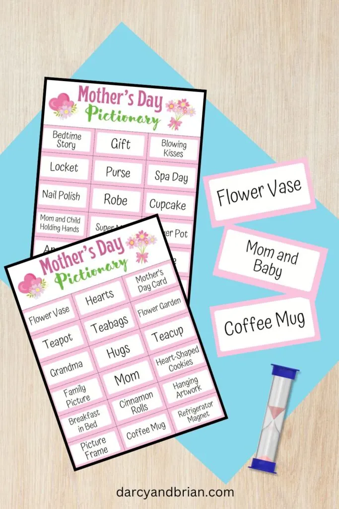 Mother's Day Pictionary word list pages overlapping each other. Three game cards lay next to them with a sand timer on a table.