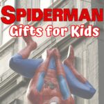 Red and white text says Spiderman Gifts for Kids. A large plastic Spiderman hanging from a chain in front of a building is the background.