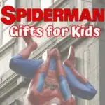 Red and white text says Spiderman Gifts for Kids. A large plastic Spiderman hanging from a chain in front of a building is the background.