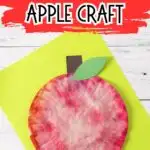 Text at top on red brush stroke background says Coffee Filter Apple Craft. The completed project is laying on top of bright yellow-green paper.