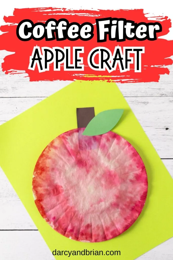 Text at top on red brush stroke background says Coffee Filter Apple Craft. The completed project is laying on top of bright yellow-green paper.