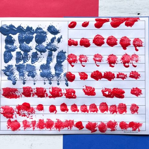 Close view of finished preschool flag painting using pom pom balls.