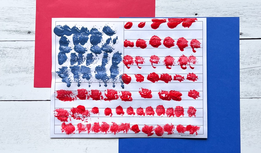 Close view of finished preschool flag painting using pom pom balls.