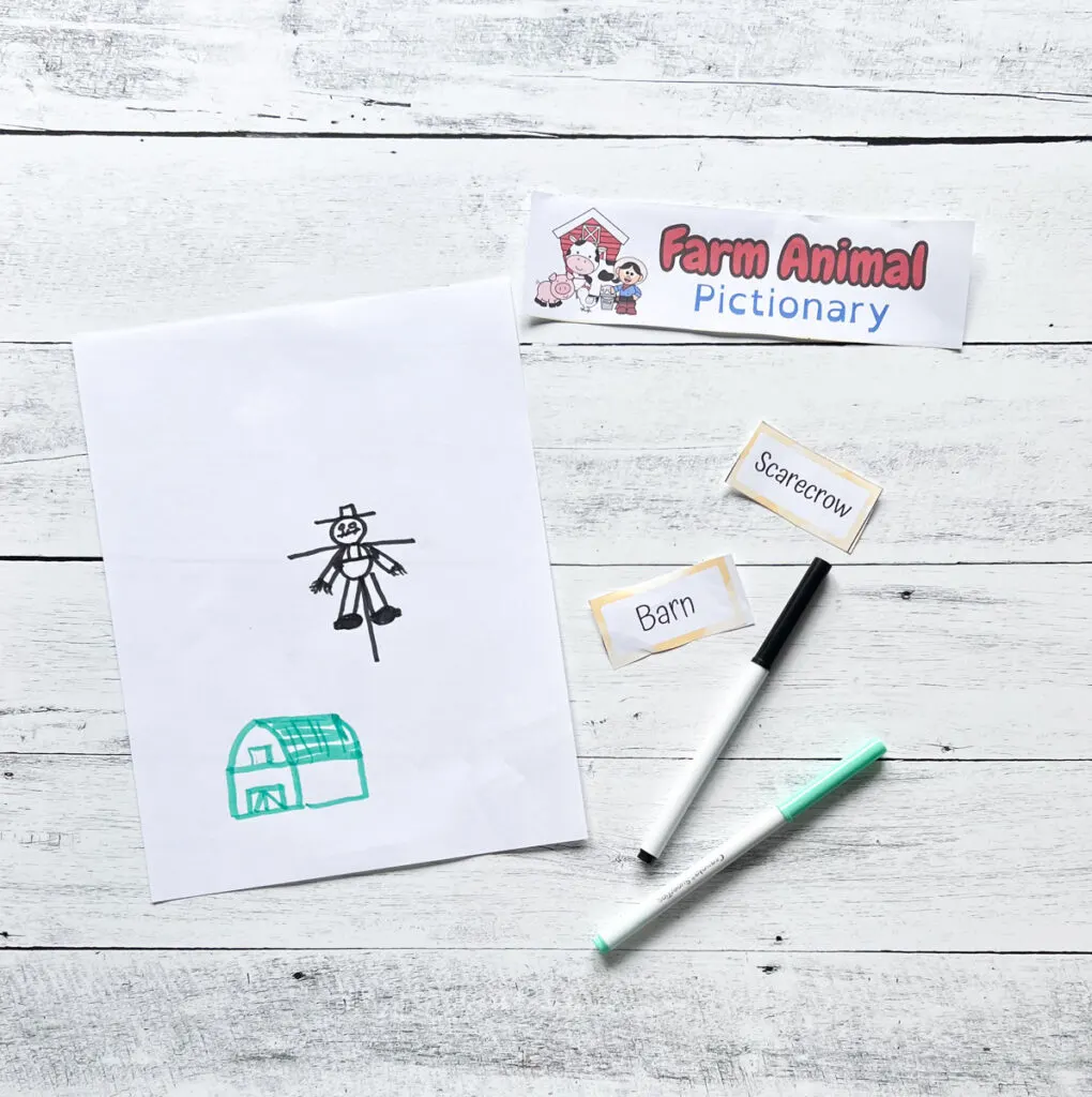 A barn and a scarecrow drawn with green and black markers.